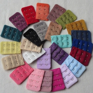 Detailed view of 3-row bra strap extenders in various colors arranged on fabric
