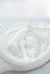 Close-up of white lace bra cup featuring breathable mesh lining and neat stitching details