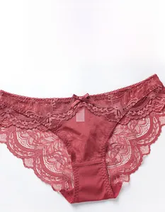Close-up of red lace panty featuring delicate mesh, bow detail and scalloped edges