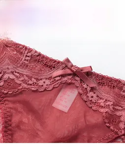 Close-up of deep red lace panties featuring floral edges and a satin bow decoration