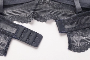 Detail of grey-blue lace bra featuring mesh fabric and three-row hook-and-eye closure