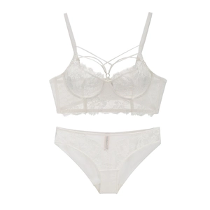 Detailed close-up of white lace lingerie set featuring cross straps and floral texture