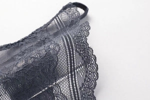 Macro detail of dark grey floral lace and sheer mesh on seamless triangle cup bra