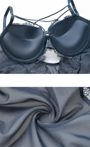 Detailed view of sheer lace mesh fabric and crossover straps on dark blue bodysuit