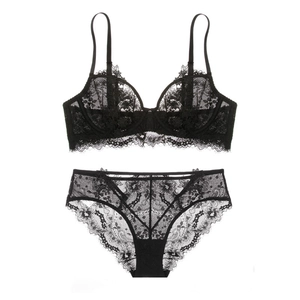 Dettaglio di un set di lingerie in pizzo nero con ricami floreali e rete velata