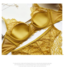 Flat lay detail of mustard yellow floral lace bra and panty set on white background