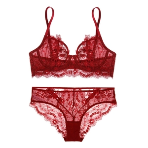 Dettaglio completo di lingerie in pizzo rosso con ricami floreali e bordi a onde
