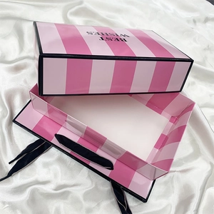 Detail of pink striped gift box with black silk handle and Best Wishes text on cover
