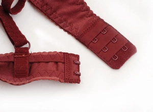 Détail de soutien-gorge en dentelle rouge foncé montrant l'agrafe et coutures renforcées