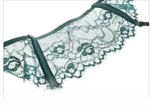 Detail of dark green sheer floral lace garter with delicate eyelash trim and strap