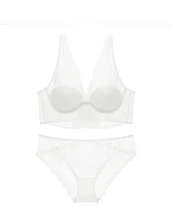 Flat lay of off-white lace lingerie set with floral patterns and scalloped edges