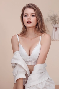 Detail of white lace bralette featuring delicate eyelash trim and V-neckline texture