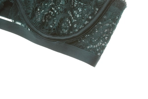 Détail macro de broderie florale en dentelle vert foncé sur bonnets en mesh transparent