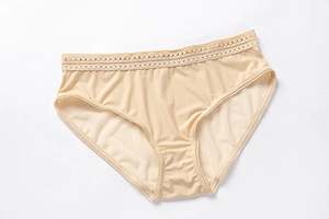 Close-up of seamless beige panties featuring delicate dotted lace trim on the waistband