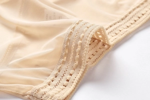 Detailed macro view of beige mesh fabric and delicate lace trim on seamless panties