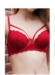 Gros plan sur un soutien-gorge en dentelle rouge avec armatures et lanières croisées