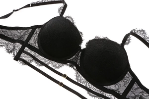 Close-up detail of black floral lace bra with elegant eyelash trim and gold metal rings