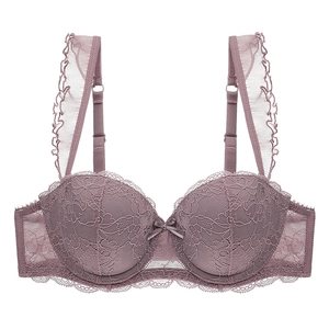 Close-up of intricate rose lace cups and delicate ruffle straps on a gathered lace bra