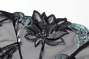 Close-up of intricate cherry embroidery and floral patterns on black sheer mesh lace