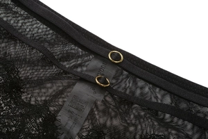Detail of black lace lingerie with golden metal rings and fine mesh texture