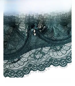 Détail d'un soutien-gorge en dentelle vert foncé avec motifs floraux et pendentif brillant
