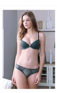 Detail view of dark green front-closure lace bra and matching sheer panties on model