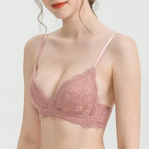 Detail of elegant French lace bralette in dusky pink with floral patterns and scalloped edges