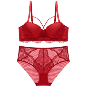 Detail eines dunkelroten Spitzen-Dessous-Sets mit floralen Mustern und Kreuzriemen