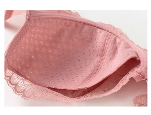 Detail of breathable mesh lining and floral lace edging on a pink bra cup