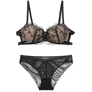 Detailed view of black floral lace embroidery on bra and matching strappy panties set