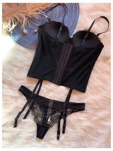 Détail d'un ensemble de lingerie en dentelle noire avec tulle à pois et jarretelles réglables