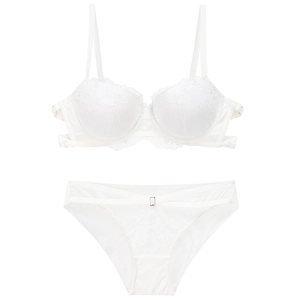 Detail of white lace lingerie set featuring intricate floral embroidery and strappy design