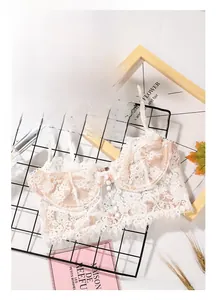 Detail of white eyelash lace bra with central button accents and sheer floral patterns