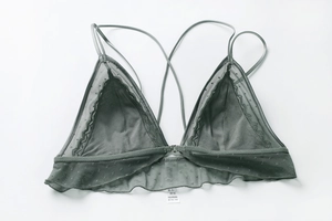 Close-up of dark grey lace bralette with front closure and crisscross straps