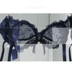 Detail view of dark blue lace bra with sheer mesh, floral embroidery and silk bow