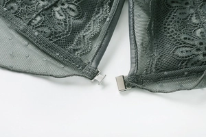 Close-up of front metal clasp and intricate lace detail on dark grey wireless bra