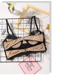 Close-up of black floral lace detailing and adjustable gold buckle on a thin bra strap