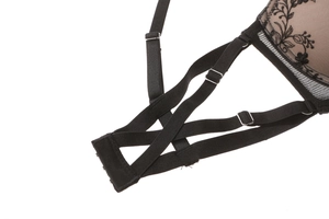 Detail of black lace embroidery with adjustable elastic straps and metal buckles