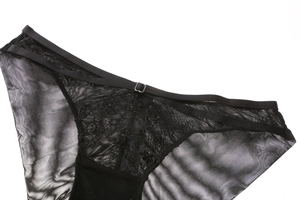 Detail of sheer black mesh panties with lace floral patterns and hollow strap design
