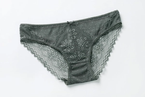Detail of dark grey lace panties with floral embroidery, scalloped edges and tiny bow