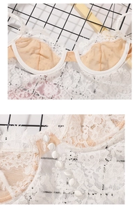 Detail of white floral lace bra with pearl buttons and scalloped embroidery trim