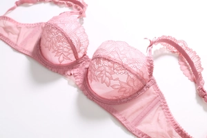 Détail de soutien-gorge en dentelle rose avec motifs floraux et mesh