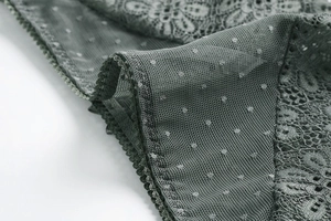 Detail of dark grey-green lace fabric with floral embroidery and mesh texture