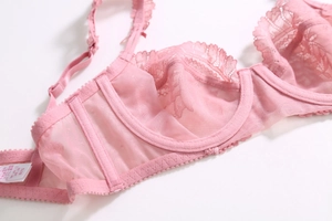 Détail de soutien-gorge en dentelle rose avec maille alvéolée et bords festonnés