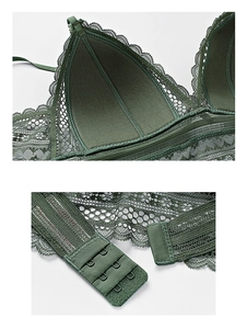 Detailed macro view of dark green lace bra showing three-row back hooks and mesh texture