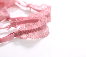 Gros plan sur la dentelle florale rose délicate avec bordure festonnée de la lingerie