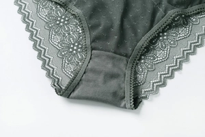 Close-up of deep green lace panties showing intricate floral patterns and mesh details