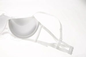 Close-up of white lace embroidery bra detail featuring multi-strap back and hook closure