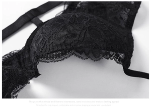 Detailed close-up of intricate floral lace texture and eyelash fringe on black bra