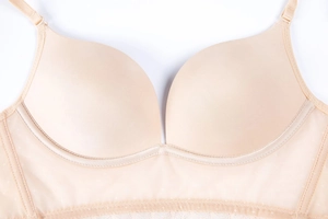 Detail view of seamless beige bra showing breathable mesh and delicate lace trim